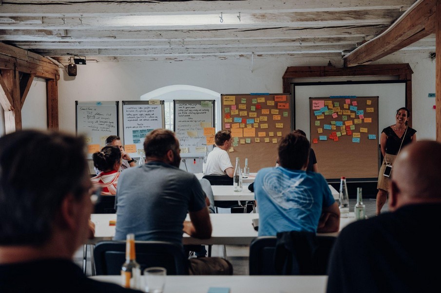 Das Team hört einer Präsentation beim Offsite zu